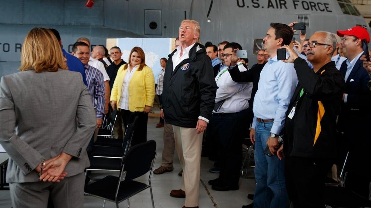 El presidente Donald Trump (centro) saluda a los reunidos en una sesión de información sobre el huracán María en la base aérea Luis Muñiz, en San Juan, Puerto Rico, el 3 de octubre.