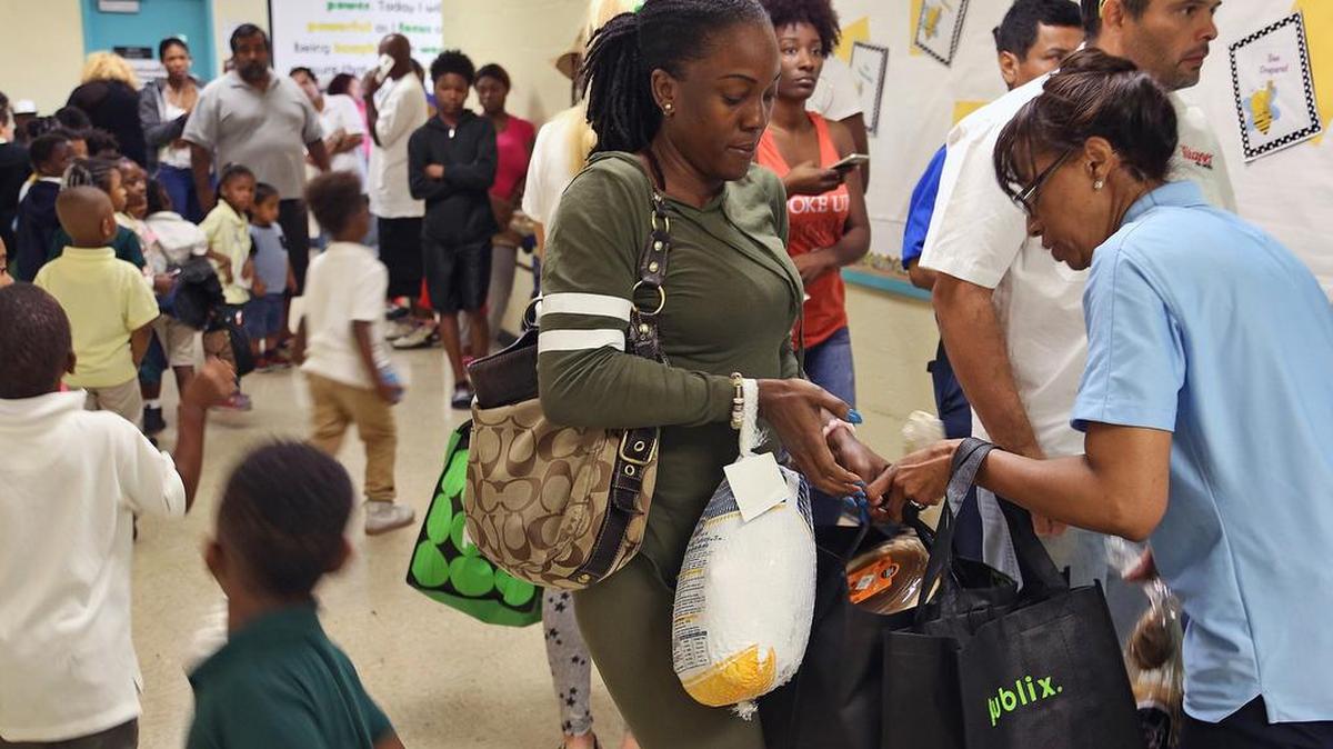Familias de escasos recursos reciben comidas de Acción de Gracias en Biscayne Bay Kiwanis Club. WalletHub calificó a Miami como una de las ciudades menos generosas de la nación.