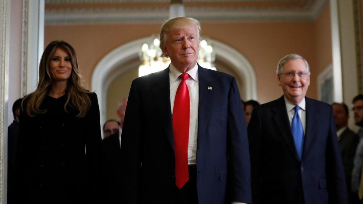 El presidente electo Donald Trump (centro) con su esposa Melania Trump y en líder de la mayoría en el Senado, Mitch McConnell, de Kentucky, a la salida de una reunión en el Capitolio, el jueves 10.