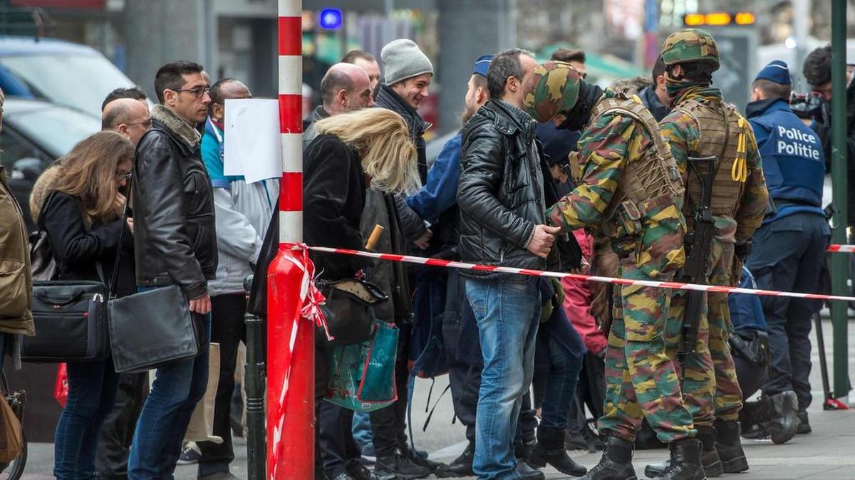 Policías y soldados registran a personas que entran en la estación del metro De Brouckere, en Bruselas, dos días después de los atentados que sacudieron a la capital de Bélgica.
