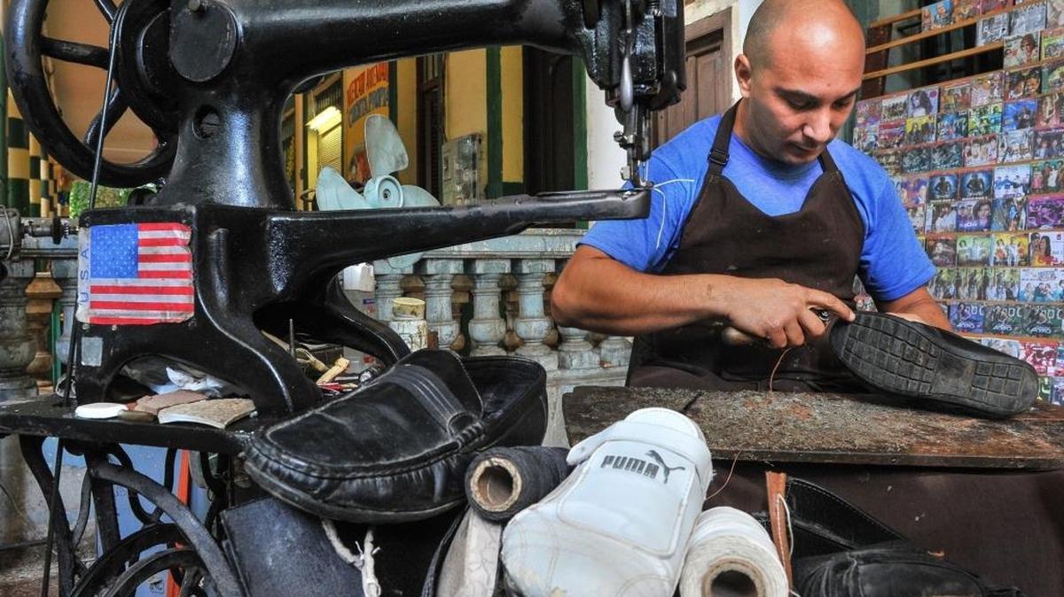 Un zapatero por cuenta propia trabaja en su taller en La Habana.