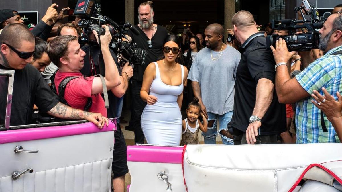 La estrella norteamericana Kim Kardashian se dispone a entrar en un auto clásico junto a su esposo, el rapero Kanye West, y la hija de ambos, North West, en La Habana, el 5 de mayo.