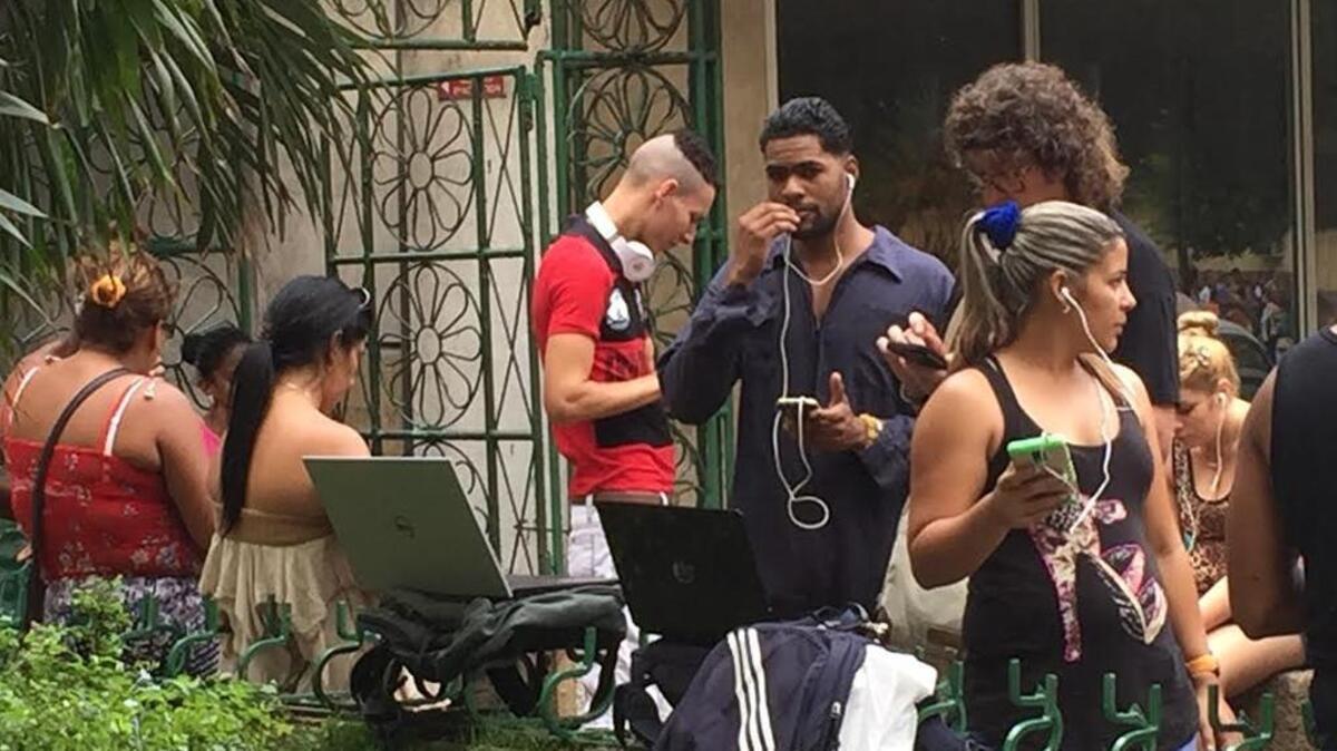 Cubanos se conectan a las redes en uno de los puntos de WiFi habilitados en la isla