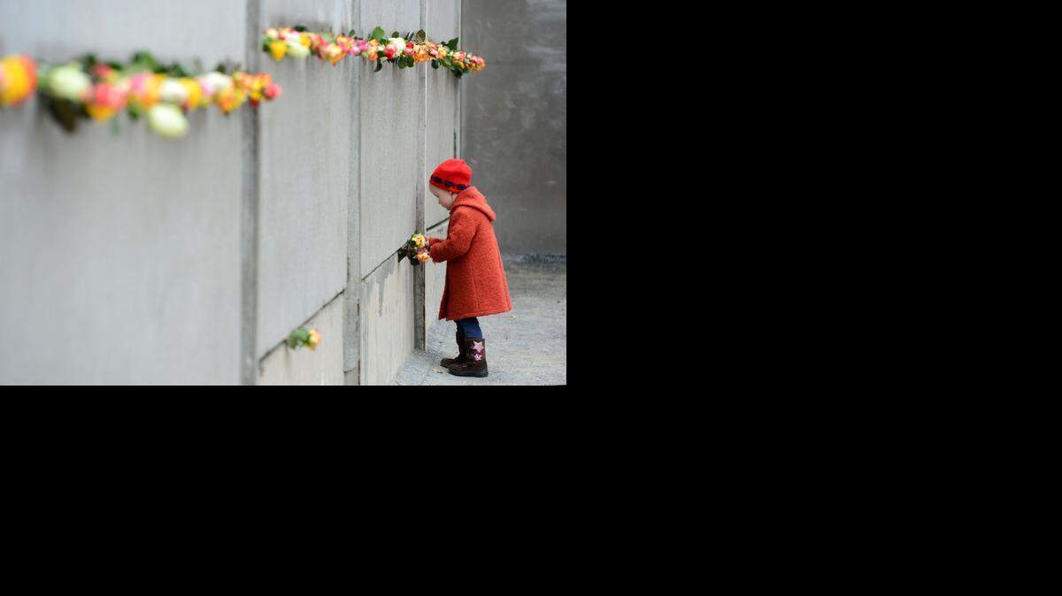 
Una niña coloca una rosa en una parte del Muro de Berlín que se ha preservado. El 9 de noviembre se cumplieron 35 años del derribo del infame Muro.


