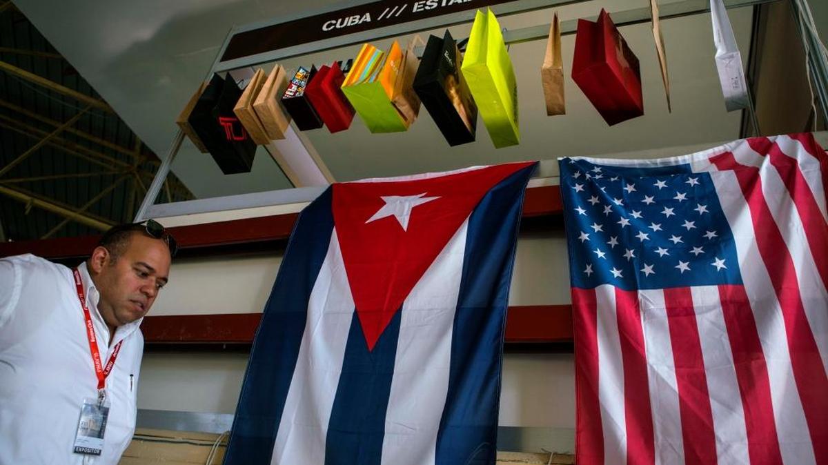 Un hombre pasa junto a una bandera de Cuba y una de Estados Unidos en la 33a. Feria Internacional de la Habana, el pasado noviembre.