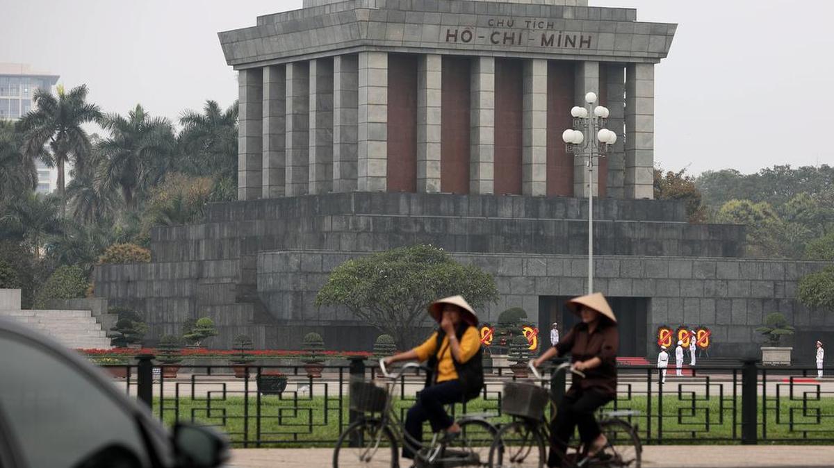 Mujeres transitan en bicicleta frente al mausoleo de Ho Chi Minh en Hanoi, Vietnam, el 19 de febrero de 2019.