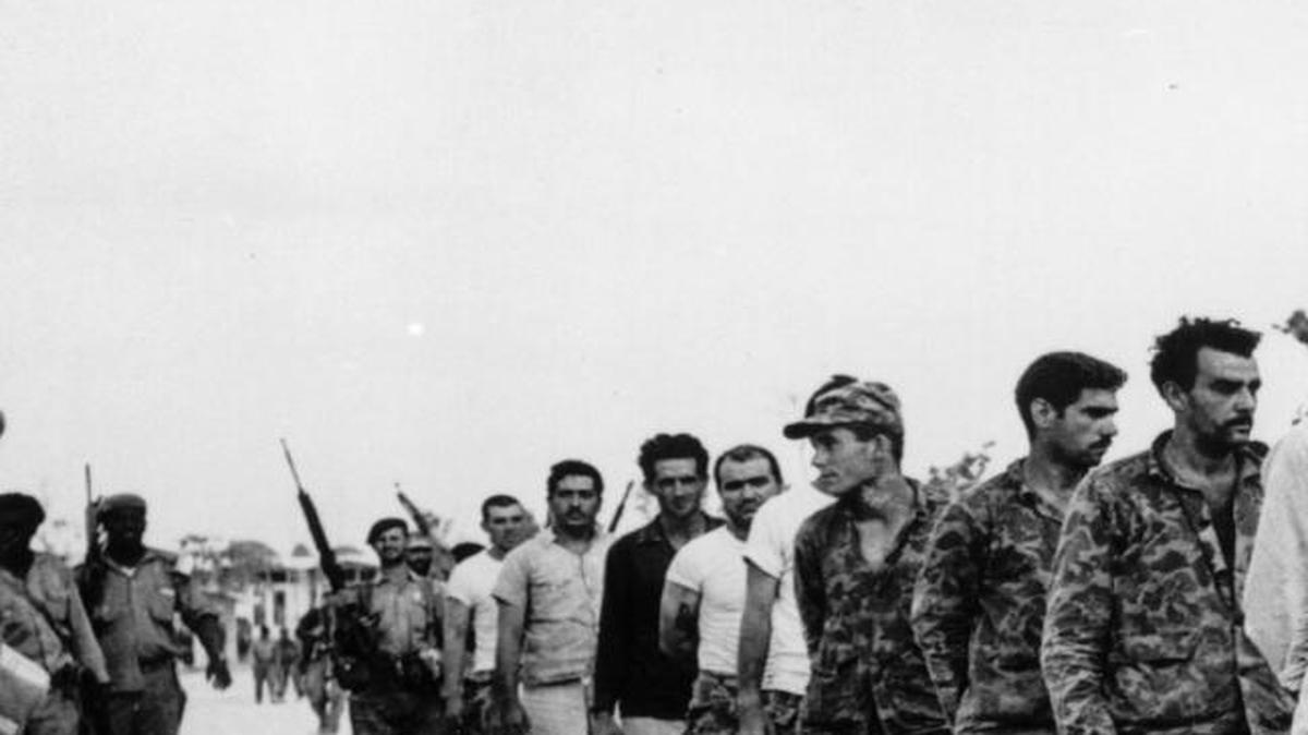 Miembros de la Brigada 2506 son vigilados por soldados castristas en Playa Girón, el 20 de abril de 1961.