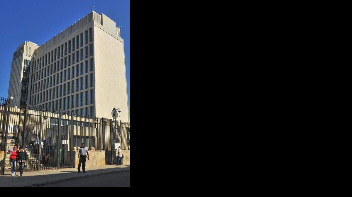 
Dos personas pasan junto a la Oficina de Intereses de EEUU en La Habana el 18 de diciembre, un día después que el presidente Barack Obama anunció el restablecimiento de las relaciones.
