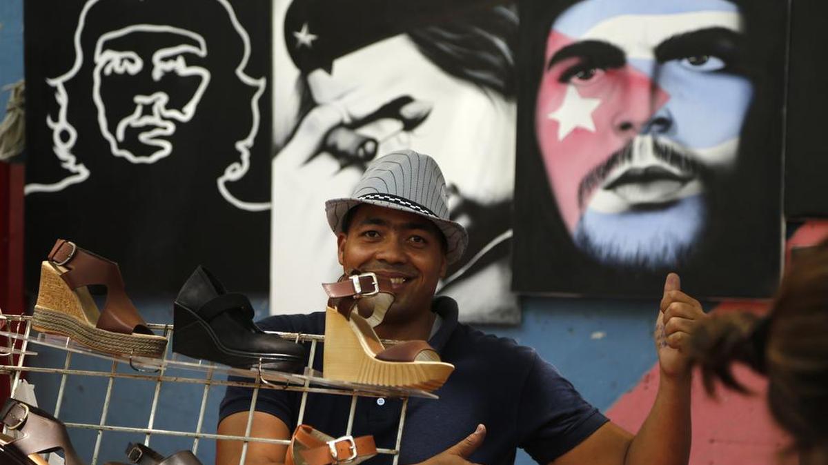 Un hombre vende zapatos y pinturas del líder guerrillero Ernesto “Che” Guevara en La Habana, en abril del 2015.