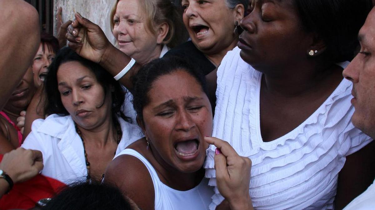 Miembros de las Damas de Blanco son hostigadas por partidarios del gobierno cubano el 18 de marzo de 2011, frente a un domicilio de La Habana donde estaban reunidas para conmemorar el octavo aniversario de la ola represiva de la “Primavera Negra” de 2003.