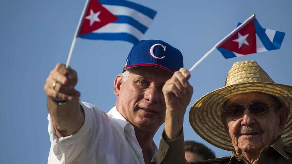 El presidente cubano Miguel Díaz-Canel (izq.) y su antecesor,Raúl Castro, agitan banderas nacionales en el desfile del Primero de Mayo en La Habana.