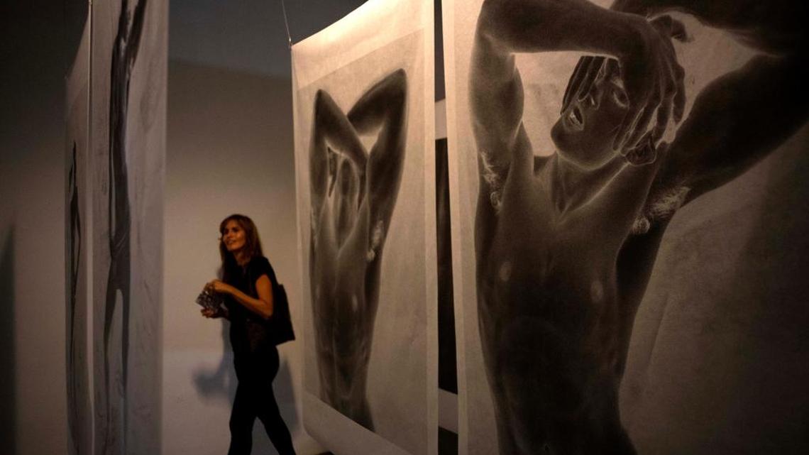 Una mujer observa obras de la exhibición del diseñador Karl Lagerfeld ‘Work in Progress’ en La Habana, el 1ro de mayo.
