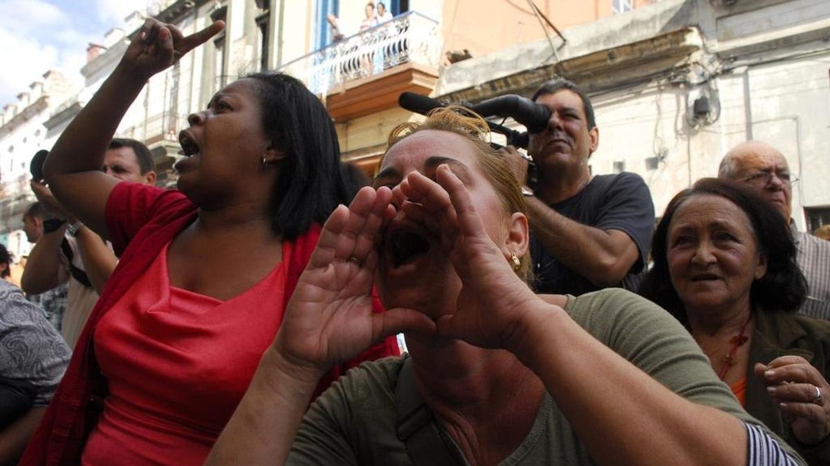 Mujeres gritan consignas revolucionarias durante un acto de repudio contra las integrantes del grupo Damas de Blanco en una marcha en La Habana.