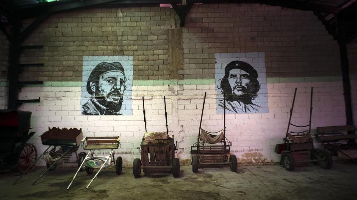 Retratos de Fidel Castro y Ernesto Che Guevara adornan un almacén de carretas de caballo usadas para transportar turistas, en La Habana.
