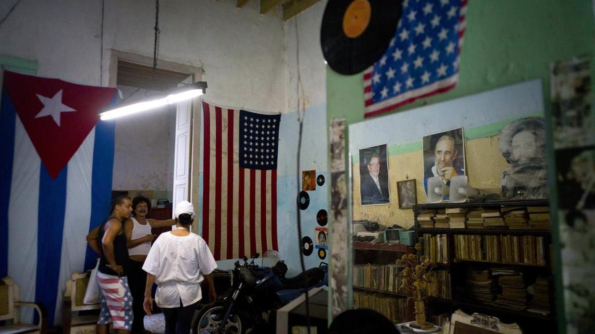 Banderas de Cuba y EEUU en la casa de Armando Ricart (centro), ex boxeador y carpintero, el martes 8 de noviembre en La Habana.