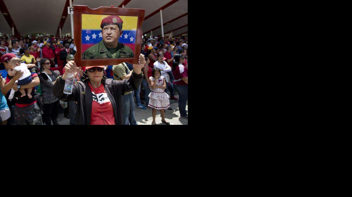 
Una mujer alza un retrato del difunto presidente venezolano Hugo Chávez en un desfile en Caracas el pasado 5 de marzo, conmemorando el primer aniversario de la muerte del líder bolivariano.
