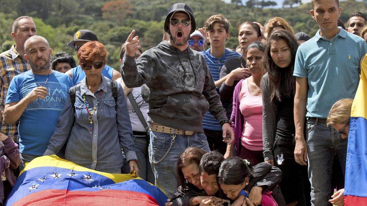 Familiares y amigos de José Díaz Pimentel, uno de los caídos en la masacre del Junquito, gritan consignas contra el gobierno durante el entierro en un cementerio de Caracas, el 20 de enero.