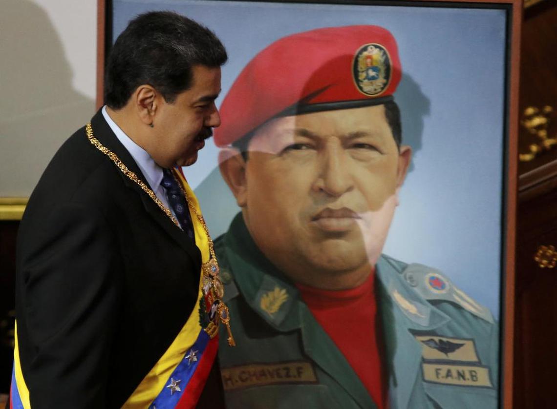 Nicolás Maduro pasa junto a una imagen de su predecesor, el fallecido presidente Hugo Chávez, en la Asambea Constituyente, para su discurso anual al país, en Caracas, Venezuela, el 14 de enero del 2019.