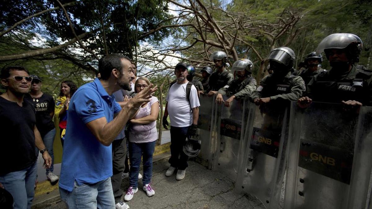 Un familiar de Abraham Agostini, uno de los compañeros del policía rebelde Oscar Pérez, discute con policías venezolanos que no lo dejan entrar al cementerio en Caracas donde sepultaron a Agostini. Pérez y seis seguidores fueron abatidos el 15 de enero por las fuerzas del gobierno.