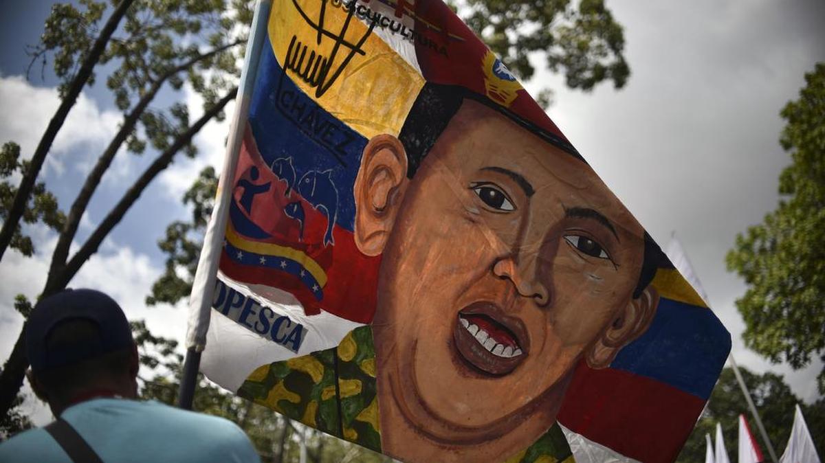 Un simpatizante del Partido Socialista Unido de Venezuela (PSUV) ondea una bandera con un dibujo del fallecido ex presidente Hugo Chávez, el 6 de diciembre, en Caracas.