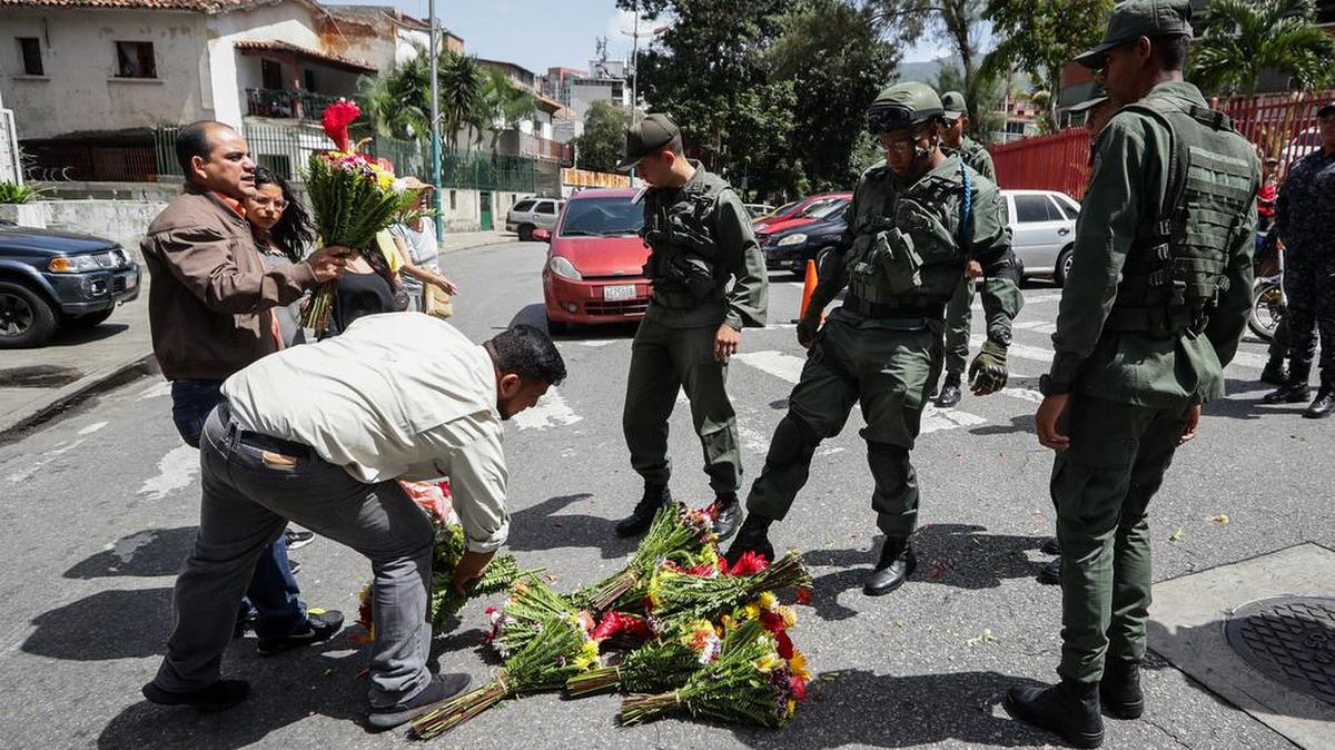 Militares patean las ofrendas florales que personas llevaron a la entrada del Comando General de la Armada Bolivariana , el martes 2 de julio de 2019, en honor al capitán venezolano, Rafael Acosta Arévalo, en Caracas. Acosta falleció el sábado 29 de junio tras ser presuntamente torturado en la sede de la Dirección General de Contrainteligencia Militar (Dgcim), según denuncian sus familiares.
