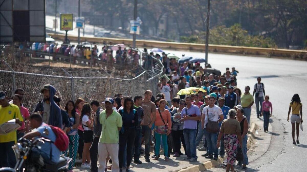Una fila de personas espera para comprar productos a los precios regulados por el gobierno, en Caracas.