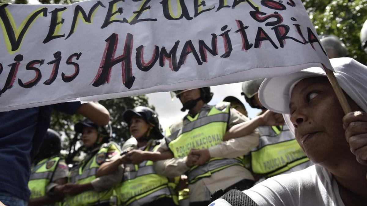 Una manifestante antigubernamental sostiene una pancarta que denuncia la crisis venezolana.