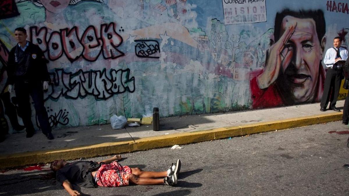 El cadáver de una mujer en un charco de sangre en una calle de Caracas.