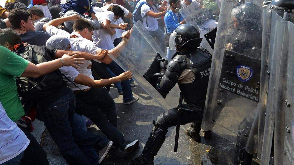 Estudiantes venezolanos chocan con la policía antidisturbios durante una protesta contra el gobierno del presidente de Venezuela, Nicolás Maduro, en Caracas, el 12 de marzo de 2014.