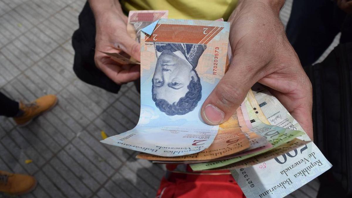 Un hombre distribuye bolívares venezolanos en la ciudad colombiana de Cúcuta, en julio.