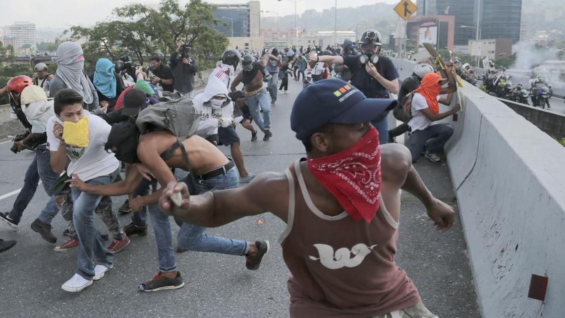 Manifestantes contra el gobierno de Nicolás Maduro lanzan piedras contra una patrulla de la policía en Caracas, el 24 de abril.