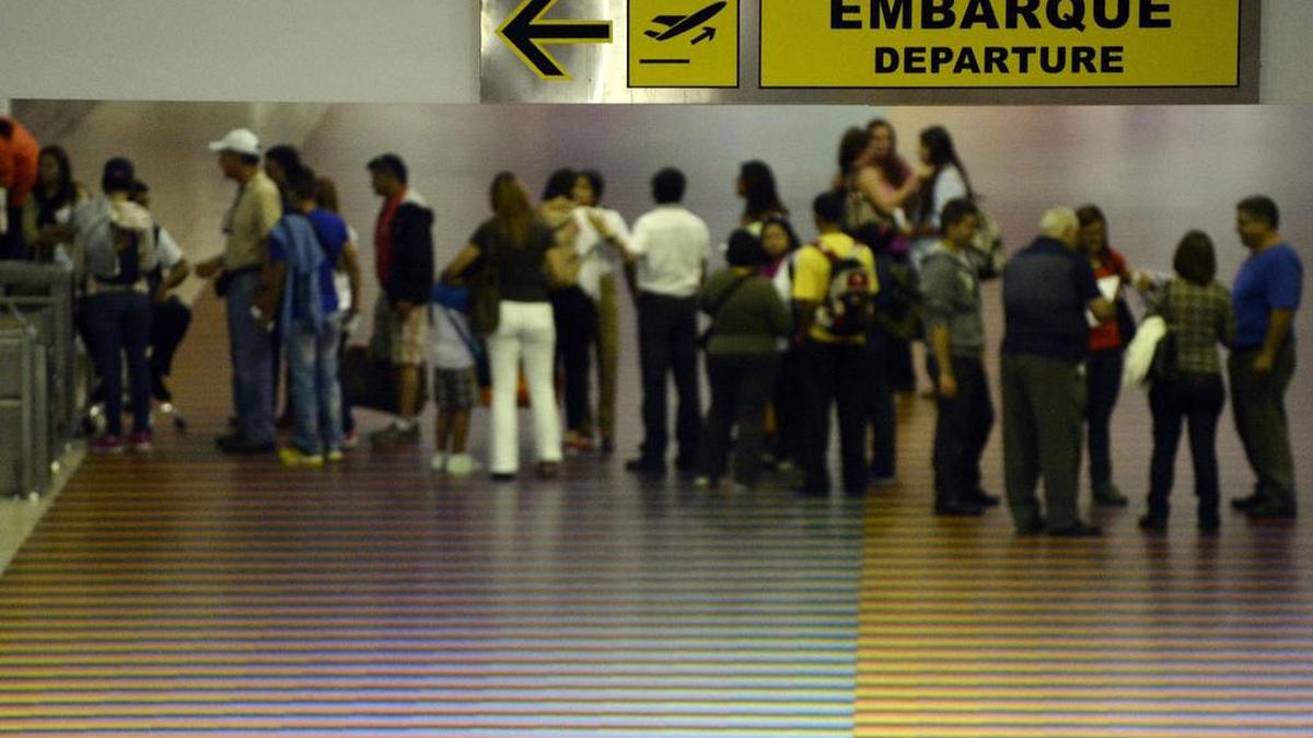 Un grupo de pasajeros hace fila en el área de salidas del aeropuerto de Maiquetía, en Caracas.