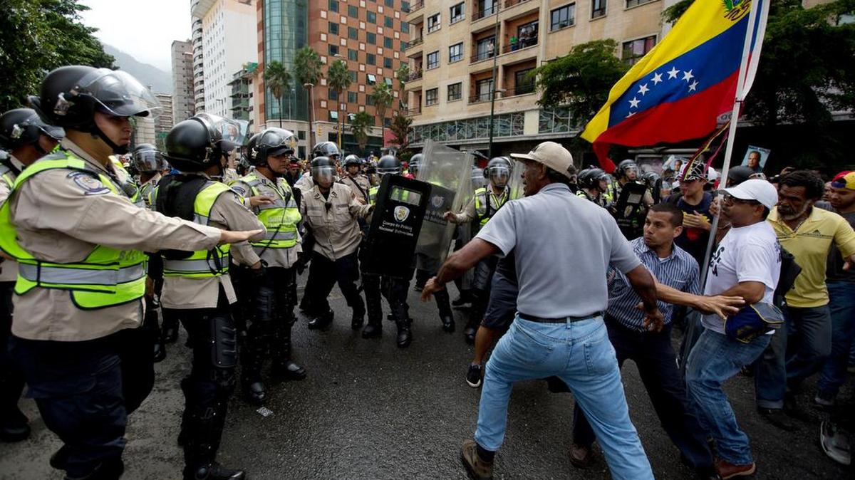 Un manifestante antigubernamental se enfrenta a la policía bolivariana para llegar a la sede del Consejo Nacional Electoral en Caracas, el 18 de mayo.