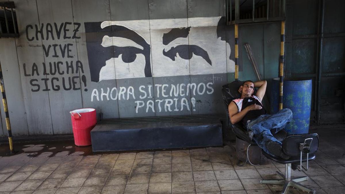 Un obrero descansa en una acerera del estado Bolívar junto a una pintura del difunto líder venezolano Hugo Chávez, el pasado noviembre.