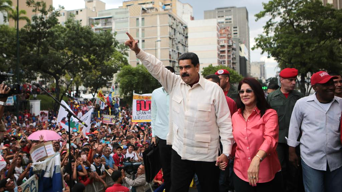 El presidente de Venezuela, Nicolás Maduro, junto a su esposa, Cilia Flores, recibe el respaldo de miles de trabajadores y estudiantes que marcharon en Caracas el 26 de mayo. Maduro afronta la posibilidad de un referendo revocatorio que busca la oposición.