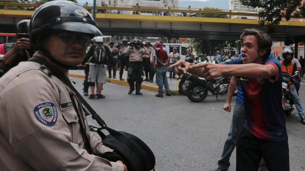 Un joven manifestante le grita a un policía durante una manifestación en Caracas, el 10 de mayo.