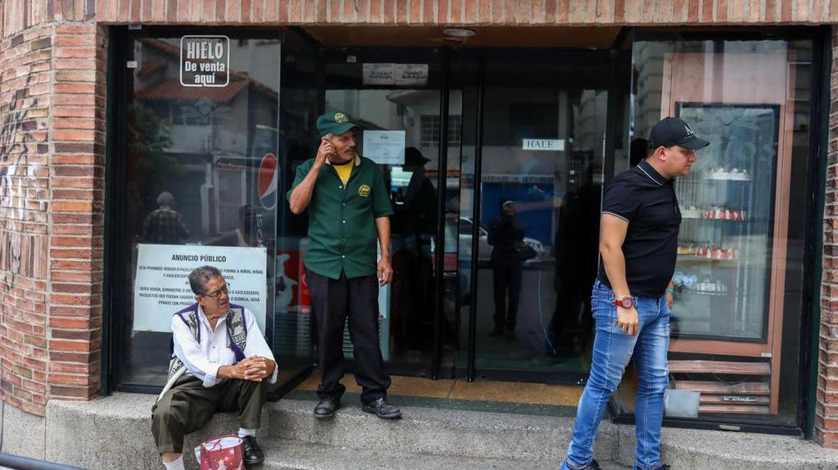 Comerciantes aguardan el restablecimiento del fluido eléctrico el jueves en Caracas. La crisis económica en Venezuela afecta al servicio de energía.