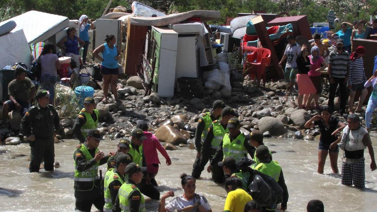 
Policías de Colombia ayudan a personas que cruzan el río Táchira desde Venezuela, en un éxodo de colombianos producido tras el cierre de la frontera que ordenó el presidente Nicolás Maduro.
