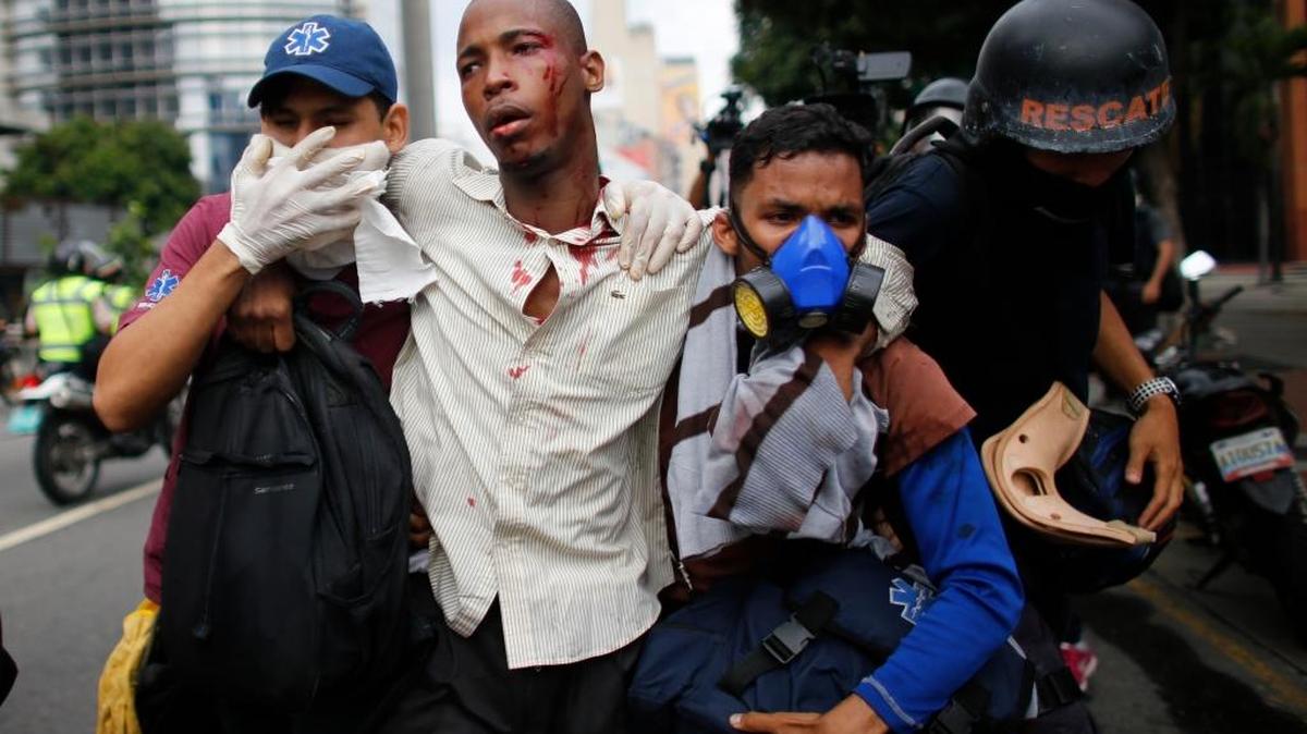 Paramédicos asisten a un herido en enfrentamientos con las fuerzas de seguridad en las protestas en Venezuela, el 20 de abril.