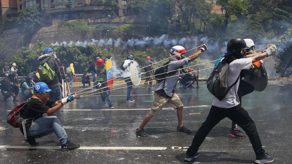 Manifestantes contra el gobierno venezolano disparan una botella con excrementos con una honda gigante contra las fuerzas de seguridad en Caracas, el 10 de mayo.