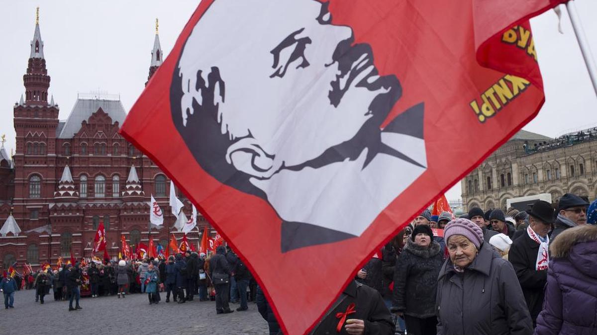 Miembros del Partido Comunista ruso marchan en la Plaza Roja, en Moscú, con un retrato del fundador de la Unión Soviética, Vladimir Lenin, en el centenario de la Revolución de Octubre.