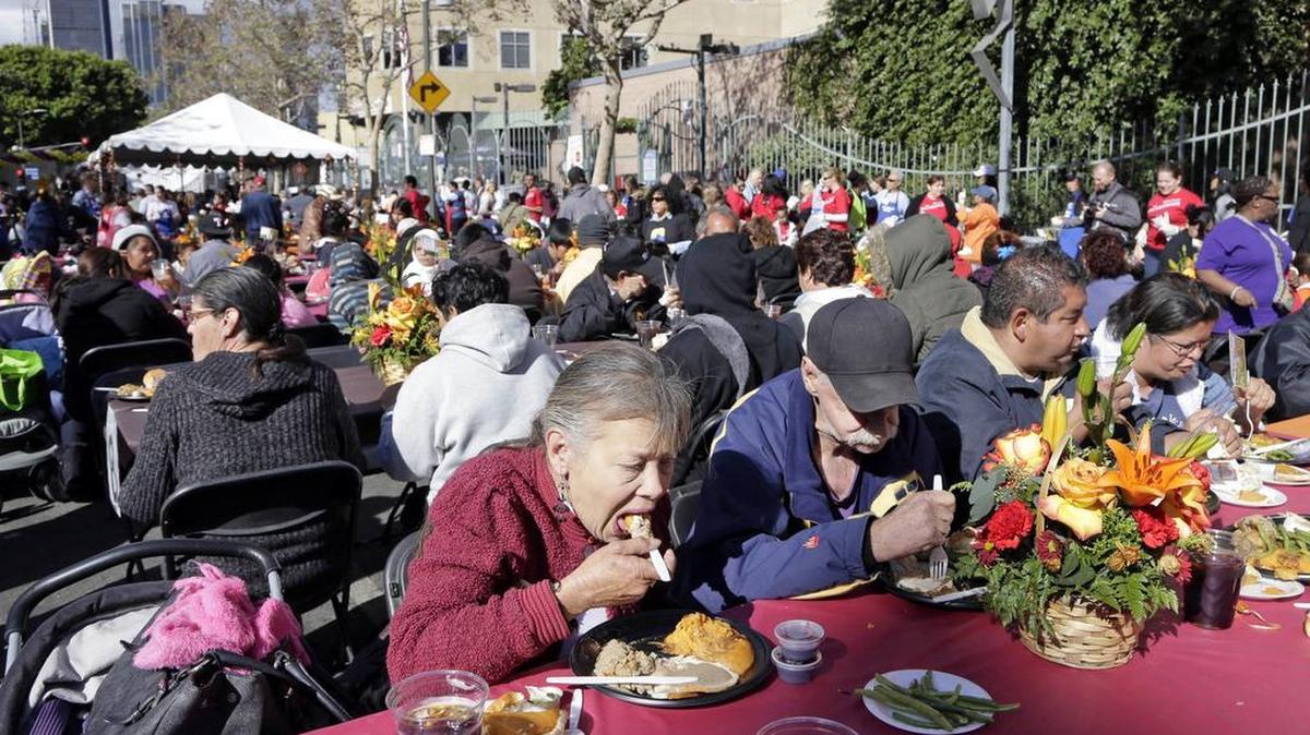 Un gran número de personas disfruta una comida de Acción de Gracias que se ofrece cada año a necesitados en Los Angeles.