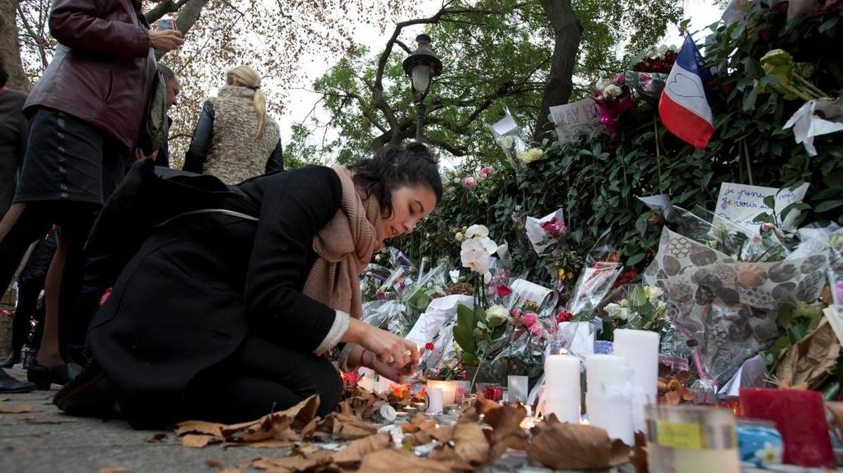 Una mujer rinde tributo a las víctimas de los ataques terroristas en París cerca de la sala de conciertos Bataclan, el martes pasado.