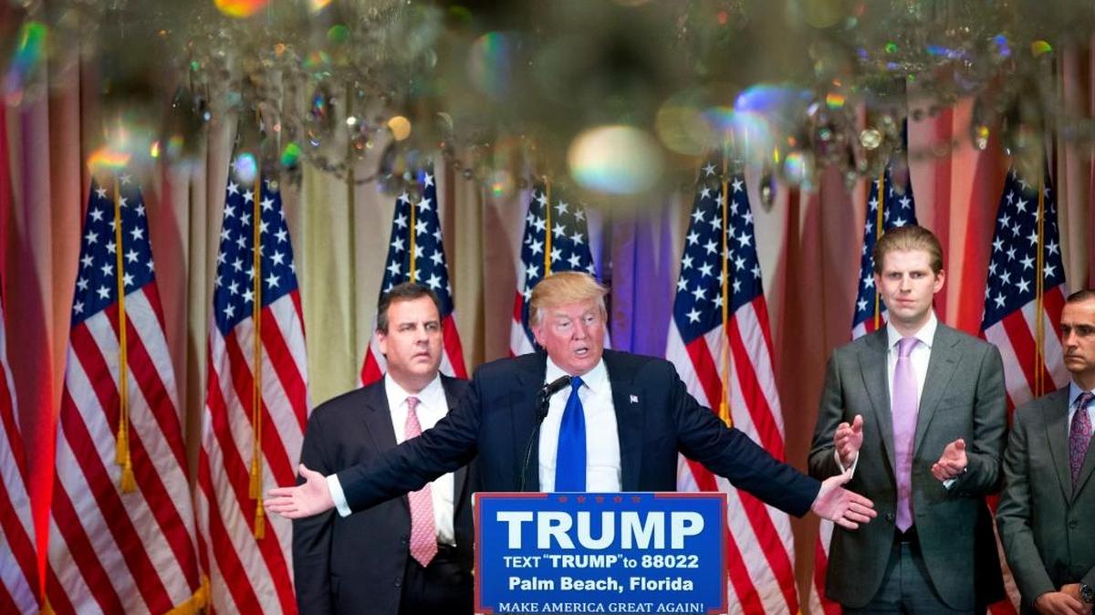 El candidato republicano (centro), junto a su hijo Eric (a su izquierda) y el gobernador de Nueva Jersey, Chris Christie (a su derecha), habla en Palm Beach sobre su triunfo en el Super Martes.