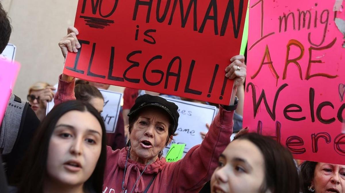 Manifestantes protestan contra la decisión del alcalde de Miami-Dade, Carlos Giménez, de abandonar la protección de ciudad santuario para los indocumentados, frente al Stephen P. Clark Center Government Center el 31 de enero, en el downtown de Miami.