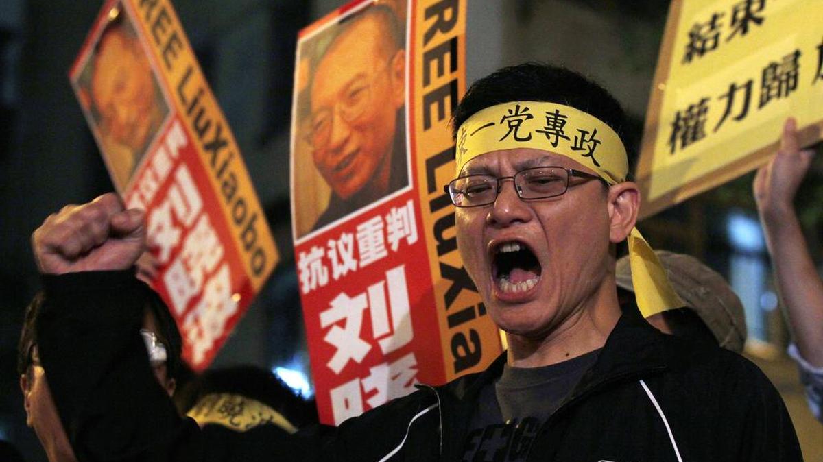 Manifestantes a favor de la democracia muestran fotos del disidente chino Liu Xiaobo en una protesta realizada en Hong Kong en el 2010. El gobierno chino mantiene una política de represión contra sus opositores.