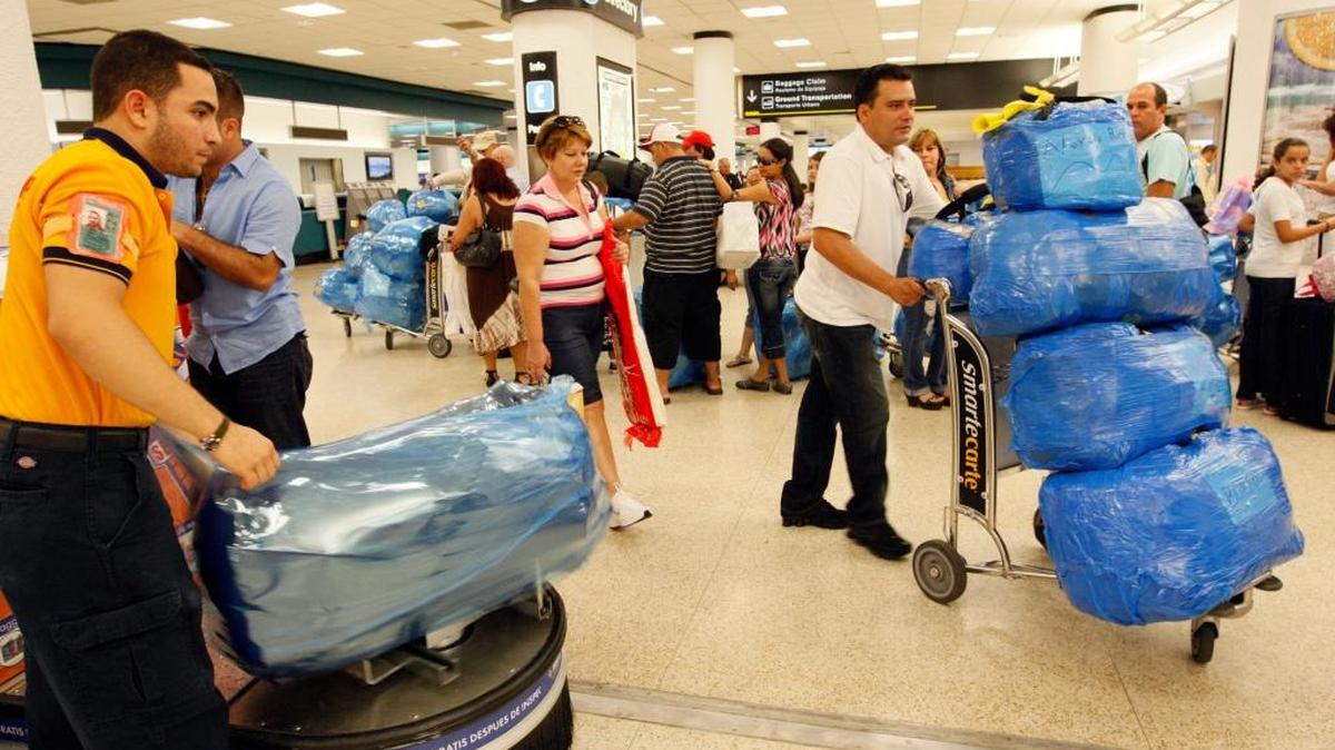 
Viajeros llevan sus malestas envueltas en plástico como medio de protección antes de salir del Aeropuerto Internacional de Miami.
