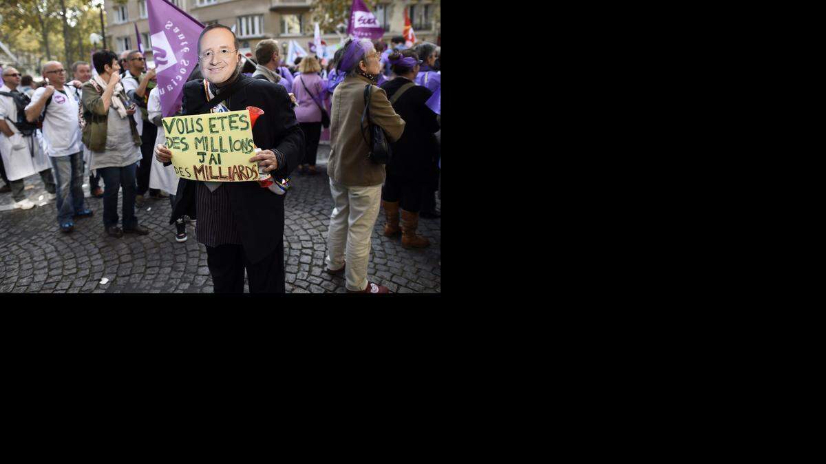 
En una protesta en París contra medidas del gobierno francés en el sector de la salud, un empleado de un hospital, disfrazado como el presidente Francois Hollande, muestra un cartel que dice: “Ustedes son millones, yo tengo miles de millones”.
