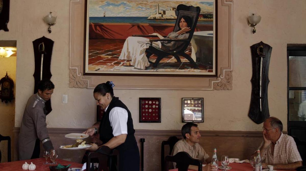 Una camarera recoge una mesa en un paladar (un restaurante privado) en la Habana Vieja. Empresarias cubanas están preocupadas por el cambio de política de Washington hacia Cuba.