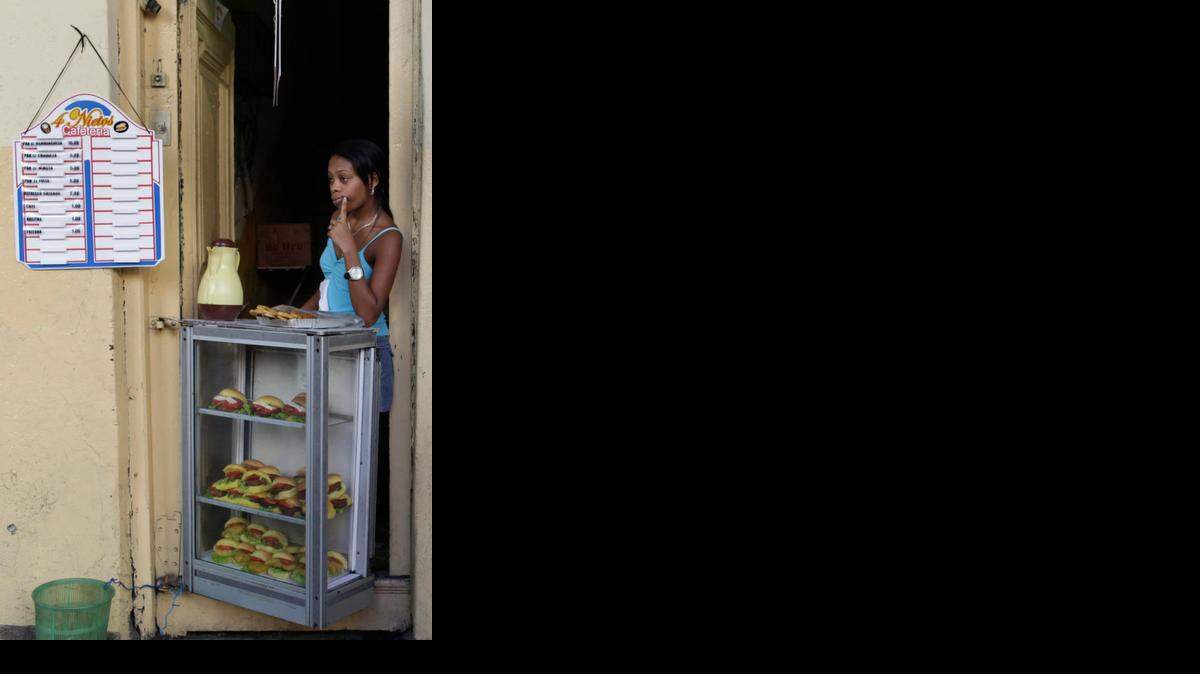 
La joven Arleti Belet espera la llegada de clientes en su puesto de sándwiches en La Habana, el pasado diciembre.
